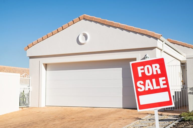A modern house with a "For Sale" sign prominently displayed in the front yard, inviting potential buyers to explore the property. This image highlights the curb appeal of the home, appealing to cash buyers and real estate investors looking to navigate the selling process.